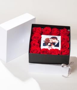 flower box con rose rosse stabilizzate e foto polaroid